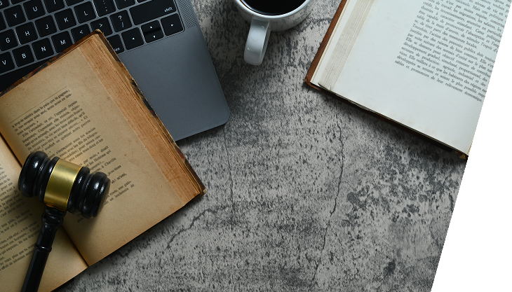 gavel on old book near laptop and mug